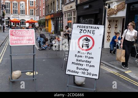 Un enfant est pris en charge par sa mère après être tombé d'un buggy jumeau à Soho, quelques jours avant le jour férié d'août, lorsque les rues de ce quartier animé de la capitale devraient être occupées pendant la pandémie du coronavirus, le 26 août 2020, à Londres, en Angleterre. Banque D'Images