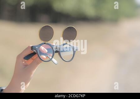 Lunettes de soleil noires à monture stéampunk avec verres ronds modèle rétro rabattable pour filmer en gros plan pendant une journée d'été. Mise au point sélective Banque D'Images