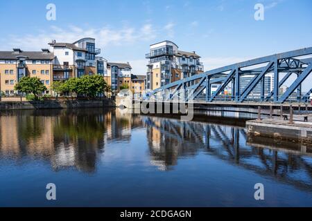 Des immeubles modernes se trouvent sur l'île de Rennie et le pont Victoria Swing Bridge, qui se reflète dans l'eau de Leith à Leith, Édimbourg, Écosse, Royaume-Uni Banque D'Images