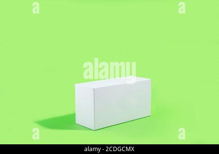 Figure géométrique blanche, rectangulaire avec des ombres sur fond vert clair. Scène minimale abstraite avec un emplacement vide pour une signature, maquette Banque D'Images