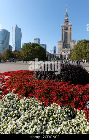 Parcourade de fleurs contre le Palais de la Culture et de la Science à Varsovie, Pologne. Le bâtiment le plus haut de Pologne a été érigé en 1955 dans le style des Sœurs d'honneur Banque D'Images