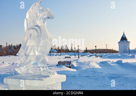 Sculpture d'oiseaux de glace sur la place Rouge enneigée et une des tours de Gostiny Dvor en hiver Tobolsk, Russie Banque D'Images