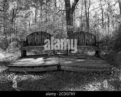 The Woodlands TX USA - 01-20-2020 - deux vieux bois Bancs côte à côte en B&W. Banque D'Images