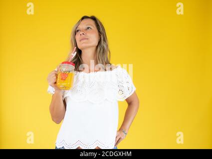 Femme en chemise blanche avec un jus d'orange Banque D'Images