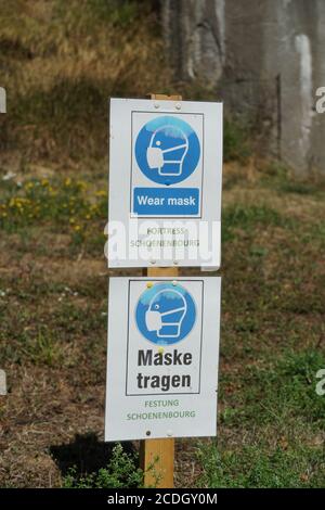 Obligation de porter un masque facial sur deux panneaux en anglais et en allemand pour les visiteurs étrangers de la forteresse Schoenenbourg sur la ligne Maginot en France. Banque D'Images