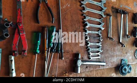 Beaucoup d'outils de réparation accrochés sur des panneaux de bois sur le mur au garage. Banque D'Images