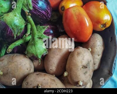 Groupes de tomates délicates, de brinjal et de pommes de terre isolés dans l'ustensile allemand Banque D'Images