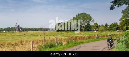 Vue panoramique du moulin à vent de Helper et vélo le long de Patersolwdsemeer près de Groningen aux pays-Bas, en Europe Banque D'Images