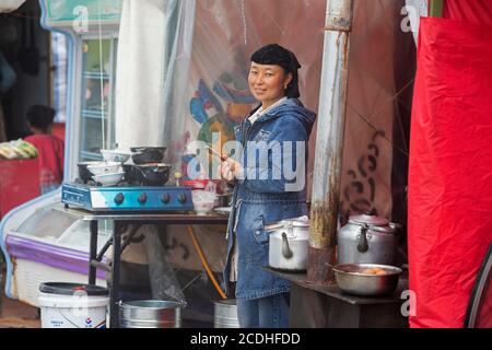 La femme tibétaine cuisine streetfood / Street food dans le petit village de l'Himalaya, en Chine Banque D'Images