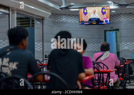 Kuala Lumpur, Malaisie. 28 août 2020. Les gens regardent un discours télévisé du Premier ministre malaisien Muhyiddin Yassin dans un restaurant à Kuala Lumpur, en Malaisie, le 28 août 2020. La Malaisie continuera d'imposer la phase de rétablissement des mesures de l'ordre de contrôle du vol pour contenir le COVID-19 jusqu'au 31 décembre, a déclaré vendredi le Premier ministre Muhyiddin Yassin, en citant les risques posés par la propagation continue de la pandémie dans le monde entier. Credit: Chong Voon Chung/Xinhua/Alay Live News Banque D'Images