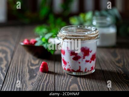 Smoothie à la framboise, Milk-Shake dans un pot en verre sur fond de bois foncé. Cocktail de yaourt. Boisson détox d'été naturelle Banque D'Images