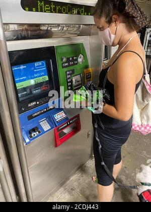 Femme avec chien en remorquage remplit sa MetroCard à la station de métro fort Hamilton Parkway à Brooklyn, New York. Banque D'Images