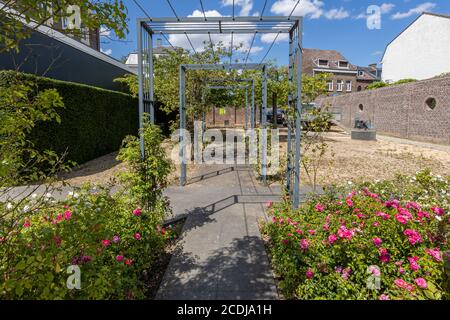 Pergolas en métal gris carré avec peu de plantes entre un trottoir piétonnier dans le jardin des roses à Sittard, perspective profonde Banque D'Images