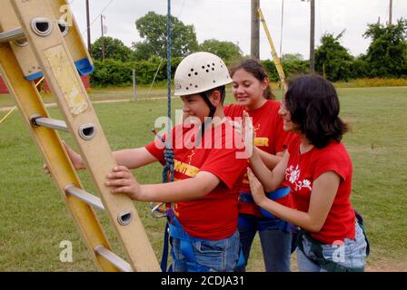 Granite Shoals, TX USA, 1er mai 2007 : des étudiants hispaniques de 12 et 13 ans de L'IDEA Academy, une école de charte publique de Brownsville, font l'expérience d'un camp d'éducation de plein air de trois jours pour favoriser le leadership et la croissance personnelle. Un garçon est encouragé par deux camarades de classe à essayer le cours de cordes hautes ©Bob Daemmrich Banque D'Images