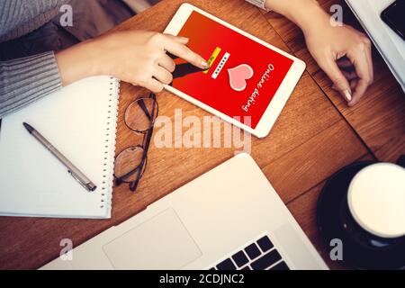 concept d'amour en ligne: fille utilisant une tablette numérique générée avec site de rencontres sur l'écran, le bureau de bois dur et la papeterie sur fond Banque D'Images