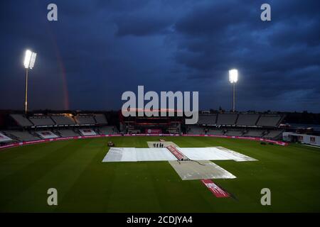 Vue générale des couvertures sur le terrain et d'un arc-en-ciel derrière le sol après que la pluie arrête de jouer pendant le match Vitality IT20 à Old Trafford, Manchester. Banque D'Images