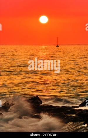 Coucher de soleil sur la plage de pierres volcaniques. Hawaï Banque D'Images