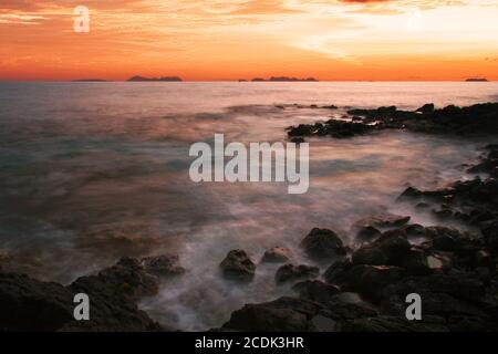 Coucher de soleil sur la plage de pierres volcaniques. Hawaï Banque D'Images