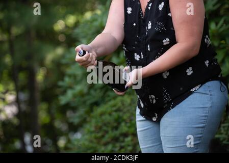 Une femme ouvre une bouteille de champagne à un fête de remise des diplômes Banque D'Images