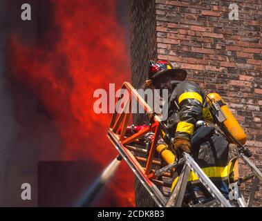 BOSTON, MASSACHUSETTS, États-Unis - pompier sur une échelle pendant un incendie dans un bâtiment. Banque D'Images