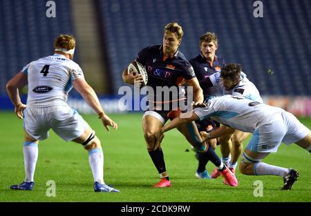 Le Duhan van der Merwe (au centre) d'Édimbourg est attaqué par Scott Cummings des Glasgow Warriors lors du match Guinness PRO14 à BT Murrayfield, Édimbourg. Banque D'Images