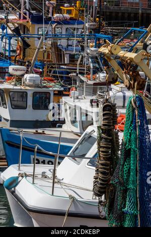 un port de pêche animé avec des chalutiers et des bateaux reliés le long dans le port ou le port pour se préparer à aller à la mer. Banque D'Images