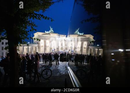 Berlin, Allemagne. 28 août 2020. Des gens se sont rassemblés à la porte de Brandebourg pour un rassemblement contre les mesures de Corona. Le paysage se reflète dans la fenêtre d'une voiture de police. Credit: Christoph Soeder/dpa/Alay Live News Banque D'Images