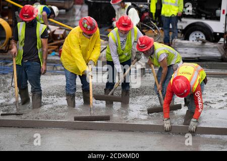 Austin, Texas, États-Unis. 22 août 2020. Des équipes de béton expérimentées effectuent un béton matinal avec lissage et mise en forme aux derniers étages d'un garage de stationnement en hauteur dans le centre-ville d'Austin le 22 août 2020. D'importants projets de construction se poursuivent sans relâche pendant les arrêts du coronavirus au Texas. Crédit : Bob Daemmrich/ZUMA Wire/Alay Live News Banque D'Images