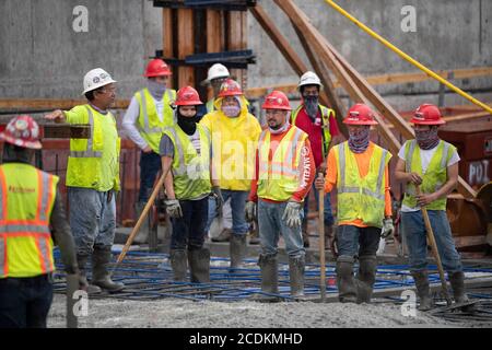 Austin, Texas, États-Unis. 22 août 2020. Des équipes de béton expérimentées effectuent un béton matinal avec lissage et mise en forme aux derniers étages d'un garage de stationnement en hauteur dans le centre-ville d'Austin le 22 août 2020. D'importants projets de construction se poursuivent sans relâche pendant les arrêts du coronavirus au Texas. Crédit : Bob Daemmrich/ZUMA Wire/Alay Live News Banque D'Images