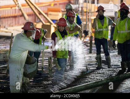 Austin, Texas, États-Unis. 22 août 2020. Des équipes de béton expérimentées effectuent un béton matinal avec lissage et mise en forme aux derniers étages d'un garage de stationnement en hauteur dans le centre-ville d'Austin le 22 août 2020. D'importants projets de construction se poursuivent sans relâche pendant les arrêts du coronavirus au Texas. Crédit : Bob Daemmrich/ZUMA Wire/Alay Live News Banque D'Images