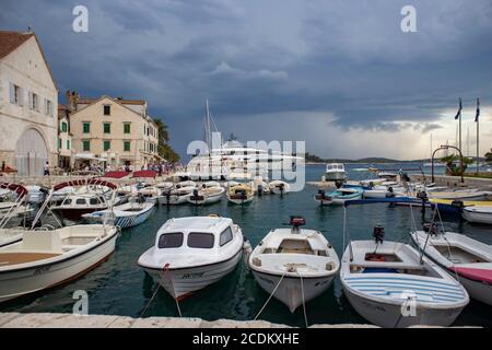 Hvar/Croatie-5 août 2020: Beau petit port au bout de la baie à la ville de Hvar, avec de grands yachts et voiliers ancrés en arrière-plan Banque D'Images