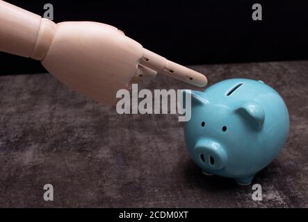 Main de mannequin en bois montrant une tirelire Banque D'Images