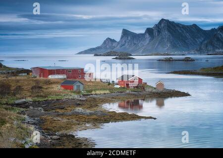 Ferme sur le fjord Rossy Straumen, en arrière-plan l'océan et les montagnes Hustinden et Bjoerntinden, Fredvang, Lofoten, Nordland, Norvège Banque D'Images