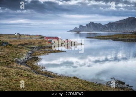 Ferme sur le fjord Rossy Straumen, en arrière-plan l'océan et les montagnes Hustinden et Bjoerntinden, Fredvang, Lofoten, Nordland, Norvège Banque D'Images