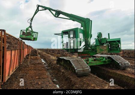 Accumulation de sodes de tourbe dans la tourbière, extraction de tourbe, chargement des sodes sèches avec une excavatrice sur chenilles, stockage de CO2, Goldenstedter Moor, Oldenburger Banque D'Images