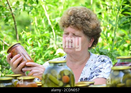 Femme au foyer mature avec une nourriture en conserve pour l'hiver Banque D'Images