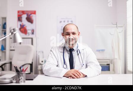Portrait d'un médecin confiant dans le bureau de l'hôpital souriant à la caméra vêtue d'un manteau blanc et d'un stéthoscope autour de son cou. Banque D'Images