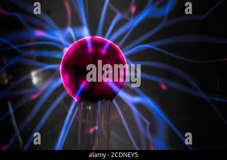Boule de plasma avec des flammes bleu-magenta isolées sur un fond noir. Banque D'Images
