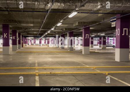 Garage de stationnement intérieur souterrain, lampes au néon dans un bâtiment industriel sombre, construction publique moderne Banque D'Images