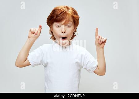 garçon aux cheveux rouges avec la bouche ouverte et l'expression stupide sur son Face affiche l'espace de copie du pouce vers le haut Banque D'Images