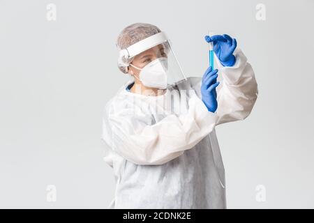 Travailleurs médicaux, pandémie de covid-19, concept du coronavirus. Femme médecin professionnelle et réfléchie en équipement de protection personnel en pensant pendant Banque D'Images