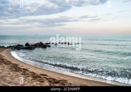 Plage de sable avec rochers et mousse de mer. Photo de paysage marin naturel. Banque D'Images