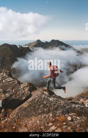 Sentier homme en montagne sur une falaise au-dessus des nuages en solo Voyage randonnées activités activités vacances en plein air en Norvège un mode de vie sain Banque D'Images