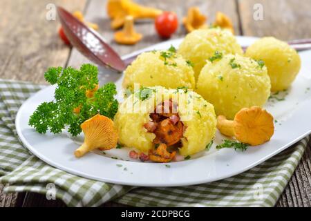 Copieux boulettes de pommes de terre d'automne farcies aux chanterelles au beurre et cubes de bacon Banque D'Images