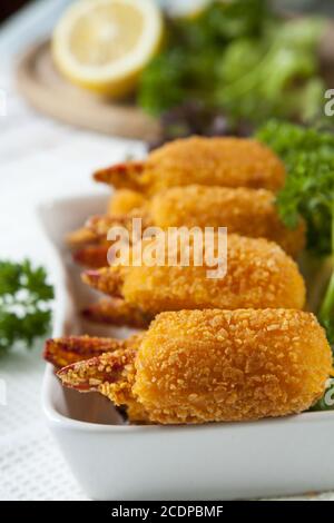 Pinces de crabe frites avec concombre, citron, laitue et persil Banque D'Images