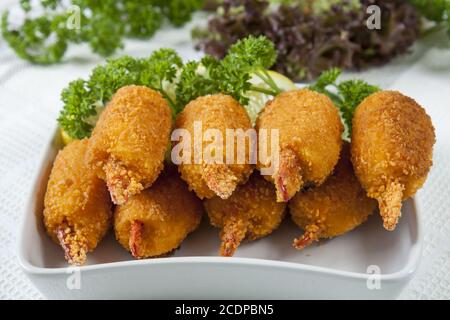 Pinces de crabe frites avec concombre, citron, laitue et persil Banque D'Images