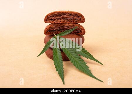 biscuits aux pépites de chocolat avec plante de marijuana à feuilles vertes. bonbons avec cannabis, pile de biscuits. Banque D'Images