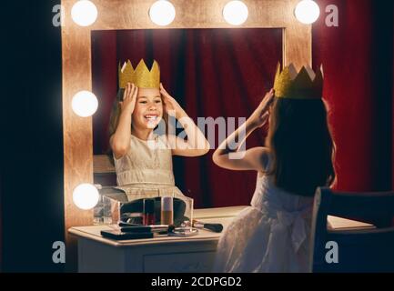 Petite actrice mignonne. Enfant fille en costume de princesse sur le fond de scènes théâtrales et de miroirs. Banque D'Images