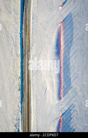 Balles de foin de neige et route noire en hiver, vue aérienne, Pologne Banque D'Images