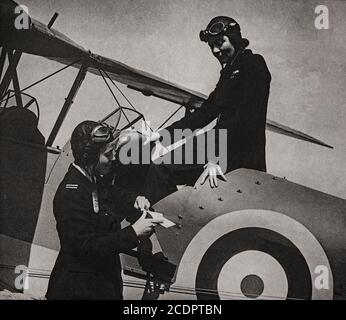 Mme Gabriel Patterson (à gauche) instructeur en conversation avec Mme Grace Brown qui a fait voler son Tiger Moth en France avec des fournitures médicales pendant l'avance allemande de 1940. Les deux étaient membres de l'auxiliaire du transport aérien (ATA) mis en place au cours de la Seconde Guerre mondiale pour acheminer des avions militaires neufs, réparés et endommagés entre des usines, des usines d'assemblage, des points de livraison transatlantiques, des unités de maintenance (MU) et des escadrons de service actif et des aérodromes. Ils ont également fait voler du personnel de service d'urgence d'un endroit à l'autre et ont effectué des travaux d'ambulance aérienne. Banque D'Images